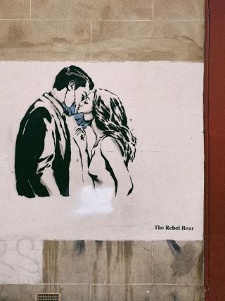 This picture is about a painting on a street of Glasgow. The artist's name is in the picture. I want to say, although, during this special period, remember, love can conquer everything. Please do not forget your life and your love.