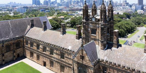 Picture of historic building on university of sydney campus with Sydney city skyline in the background