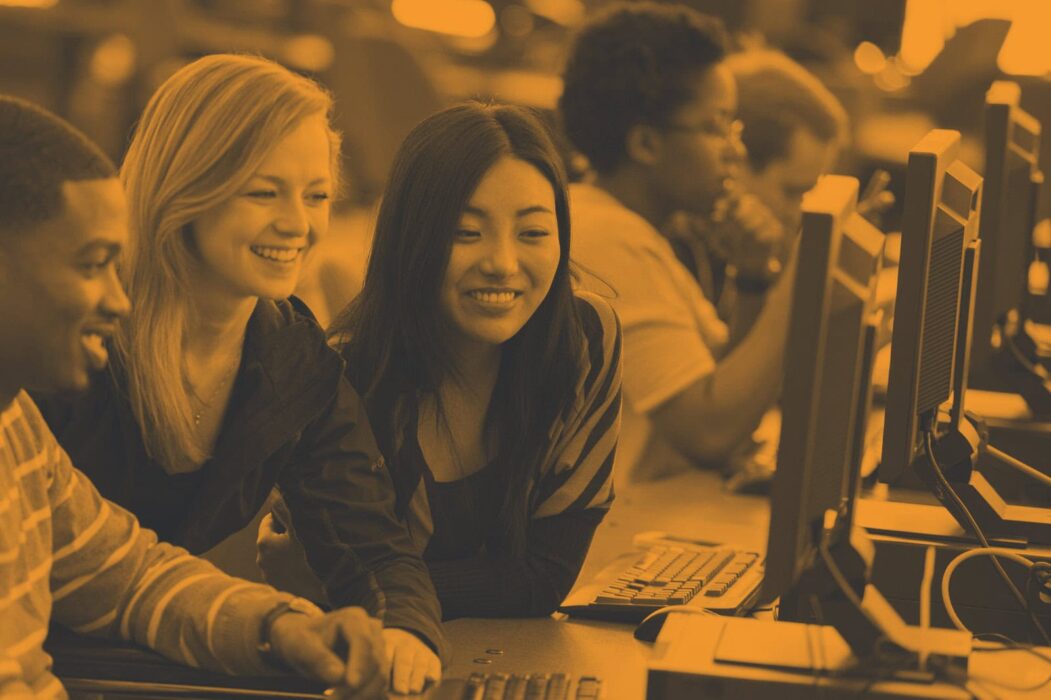 Students collaborating around a computer