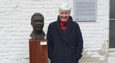 Photo of Professor Bairbre Redmond, stood by bust of Georges Henri Joseph Édouard Lemaître, father of the Big Bang theory, KU Leuven