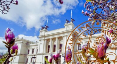 A cream building at Lund University with columns, superimposed with a magnolia tree in bud and the Lund University logo.