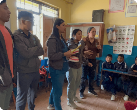 Group of students from HSG's 2024 Global Learning Partnership speaking with students in a classroom in Nepal. 