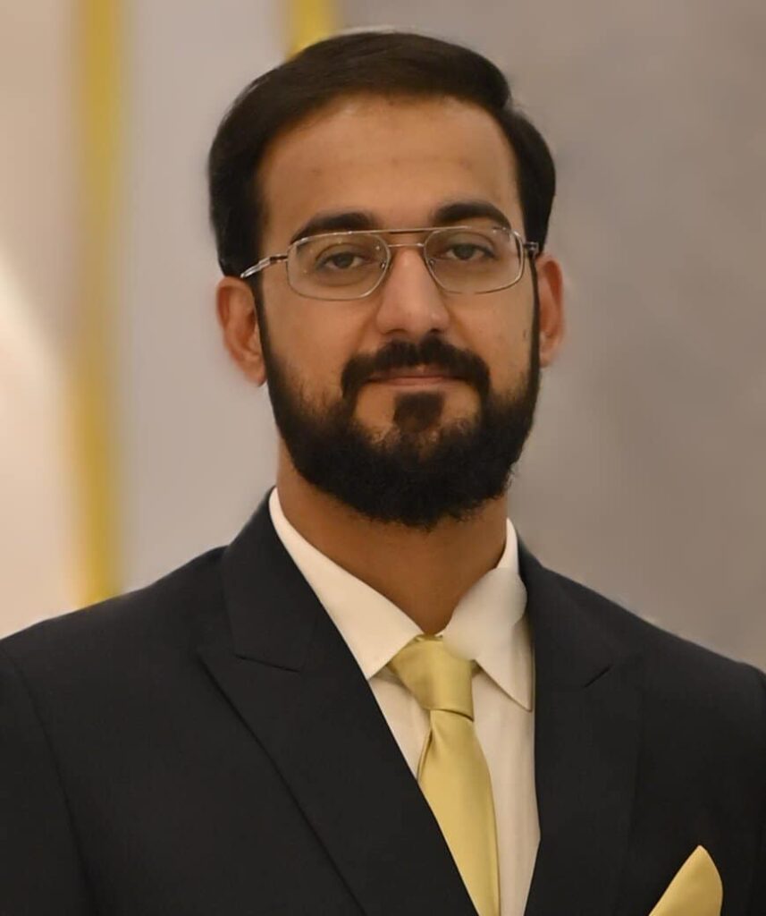 Headshot photo of Syed Saad Pasha wearing a suit and smiling to camera
