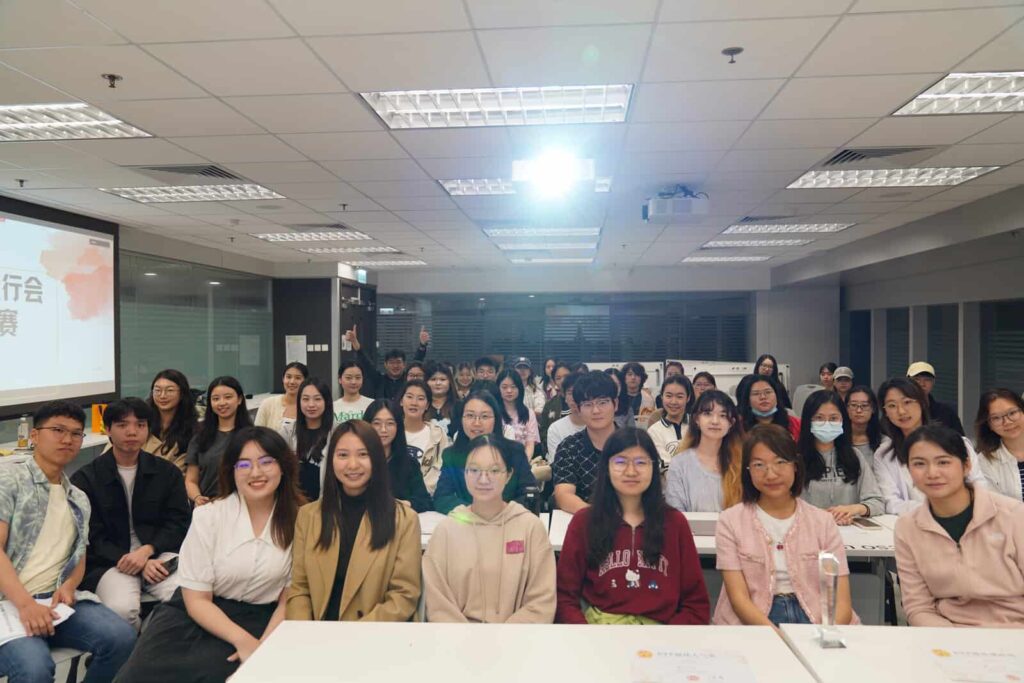 A group of people sitting at tables in a lecture theatre.