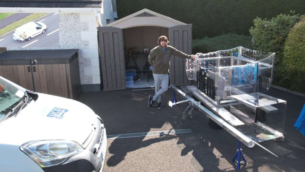 A man is standing by a large plastic container.