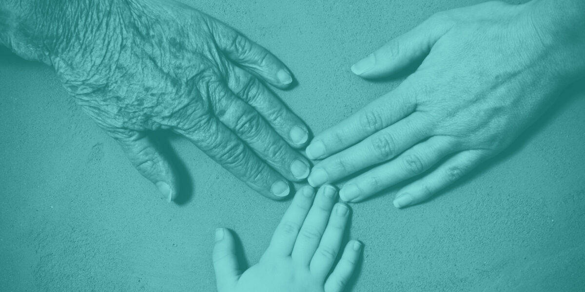 Three hands from different generations touching
