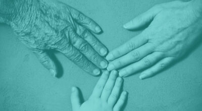 Three hands from different generations touching