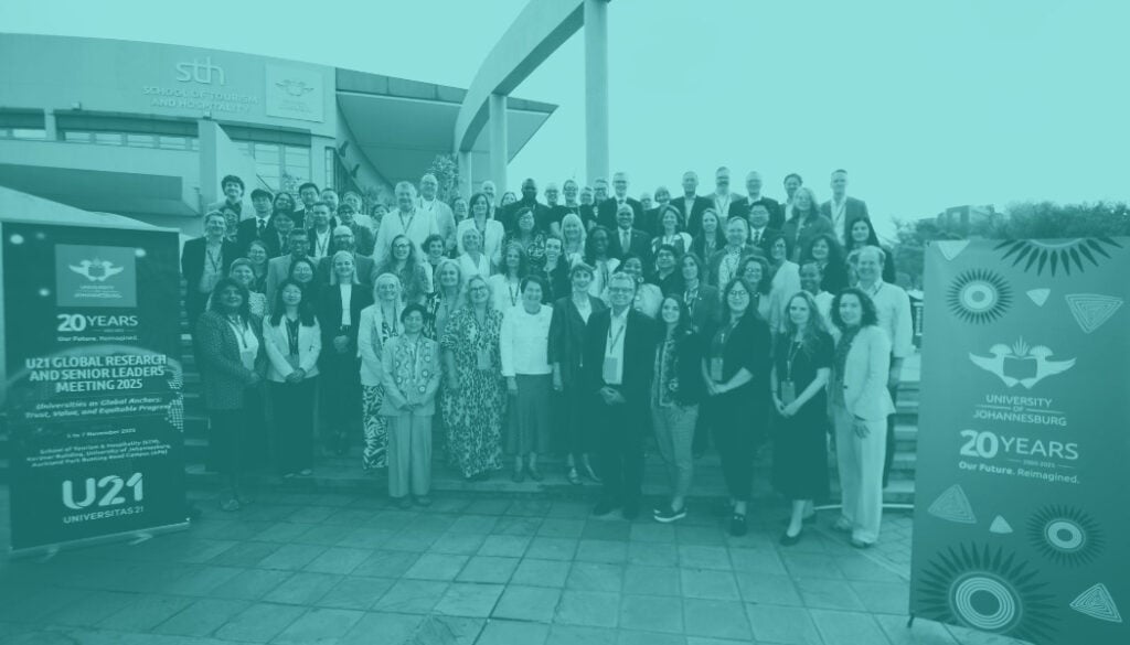 Group photo of delegates from the Global Research & Senior Leaders' Meeting standing in front of University of Johannesburg building
