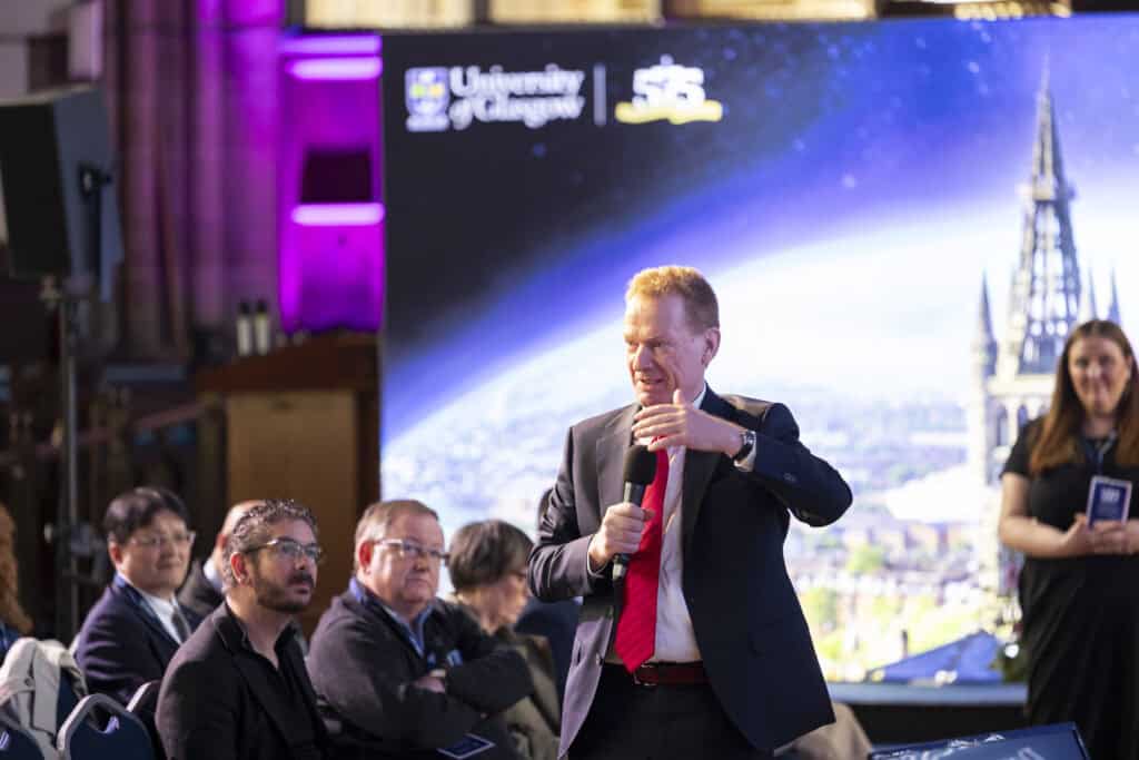 Christian Schwarzenegger in the audience at the Annual Network Meeting in Glasgow. Standing with a mic, asking a question.